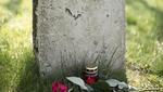 Grabstein Grabstein mit mit zwei roten Rosen und einer roten Kerze