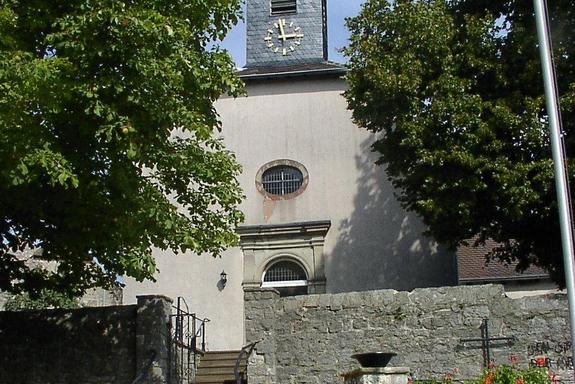 Eine alte, weiße Kirche mit Steintreppenstufen