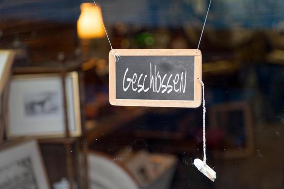 German closed sign.Writting slate hanging at the entrance of a shop saying in German "Geschlossen", meaning in English "Closed".