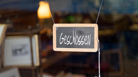 German closed sign.Writting slate hanging at the entrance of a shop saying in German "Geschlossen", meaning in English "Closed".