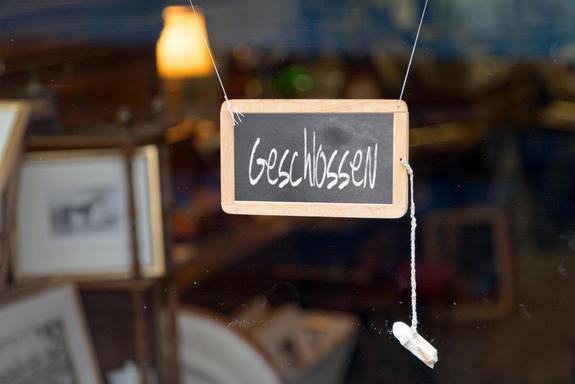 German closed sign.Writting slate hanging at the entrance of a shop saying in German "Geschlossen", meaning in English "Closed".