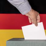 Man putting a ballot into a voting box against the background of the Germany flag